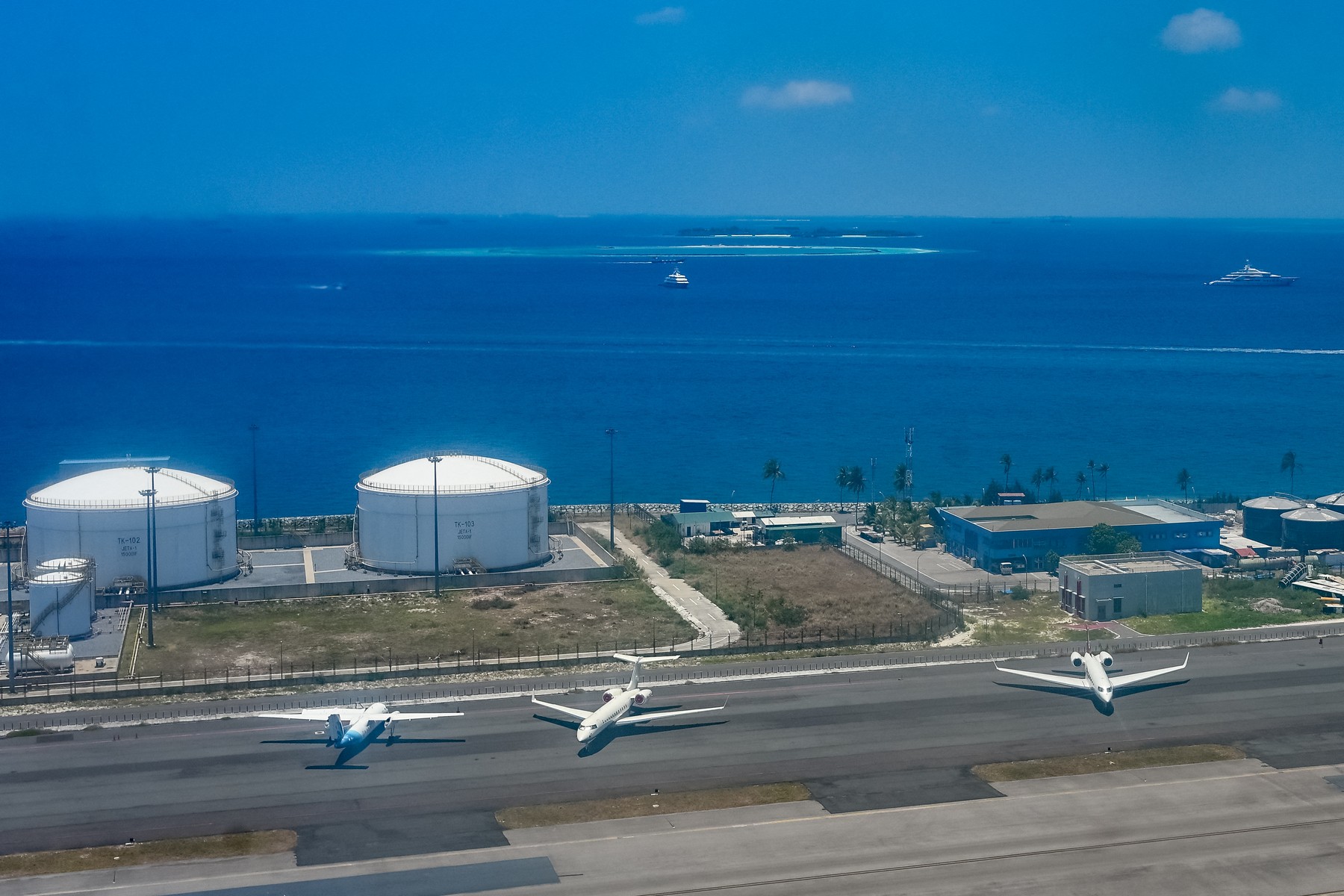 Chartered planes stand on the tarmac beside fuel storage tanks at Velana International Airport in Male on March 26, 2026