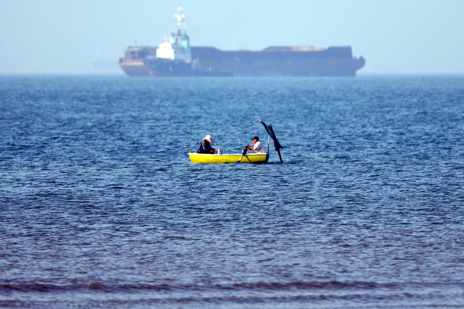 May 4, 2026, two men sitting in a skiff are seen fishin Strait of Hormuz off Bandar Abbas in southern Iran.