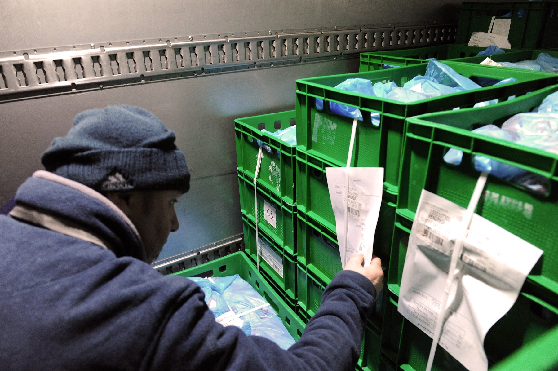 A French pig farmer checks the meat content in a refrigerated  truck