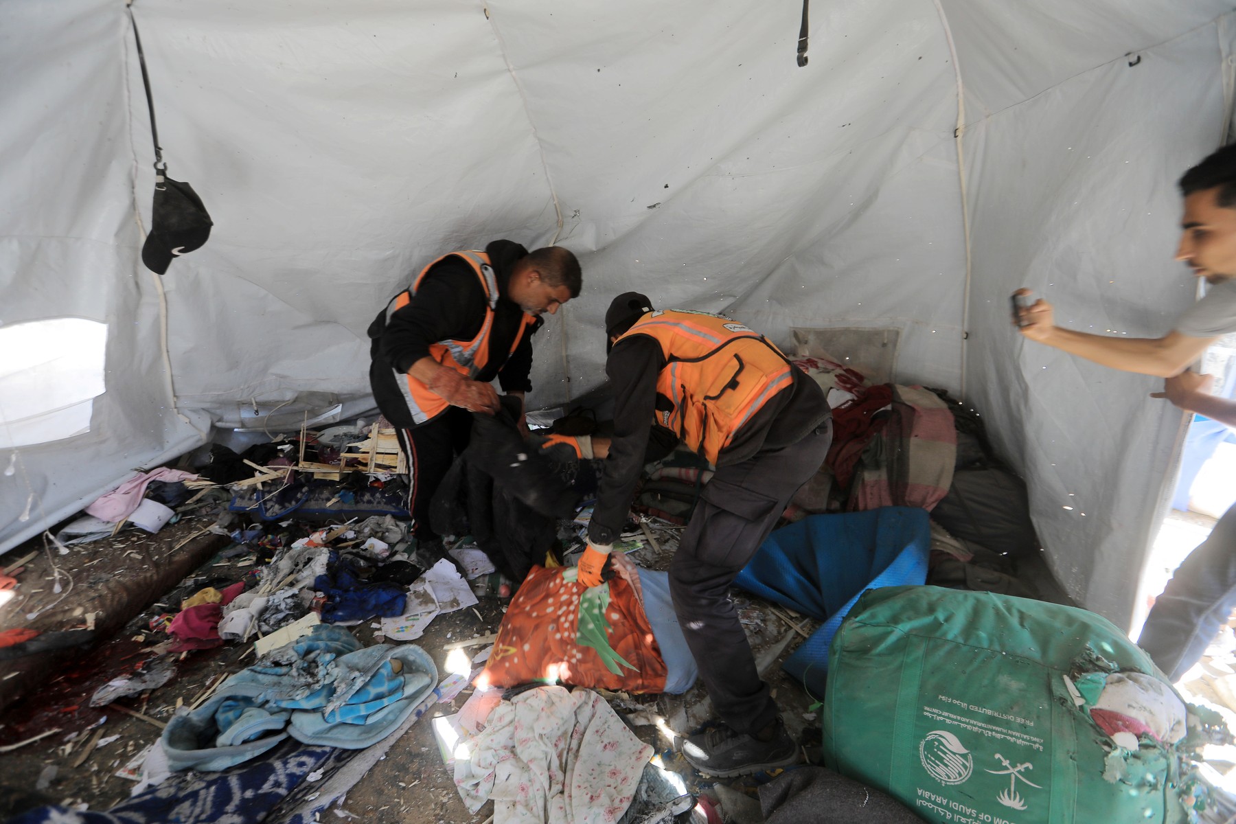 Displaced Palestinians carry wounded people and recover bodies following an Israeli airstrike that targeted tents sheltering displaced families west of Gaza City, on June 6, 2026.