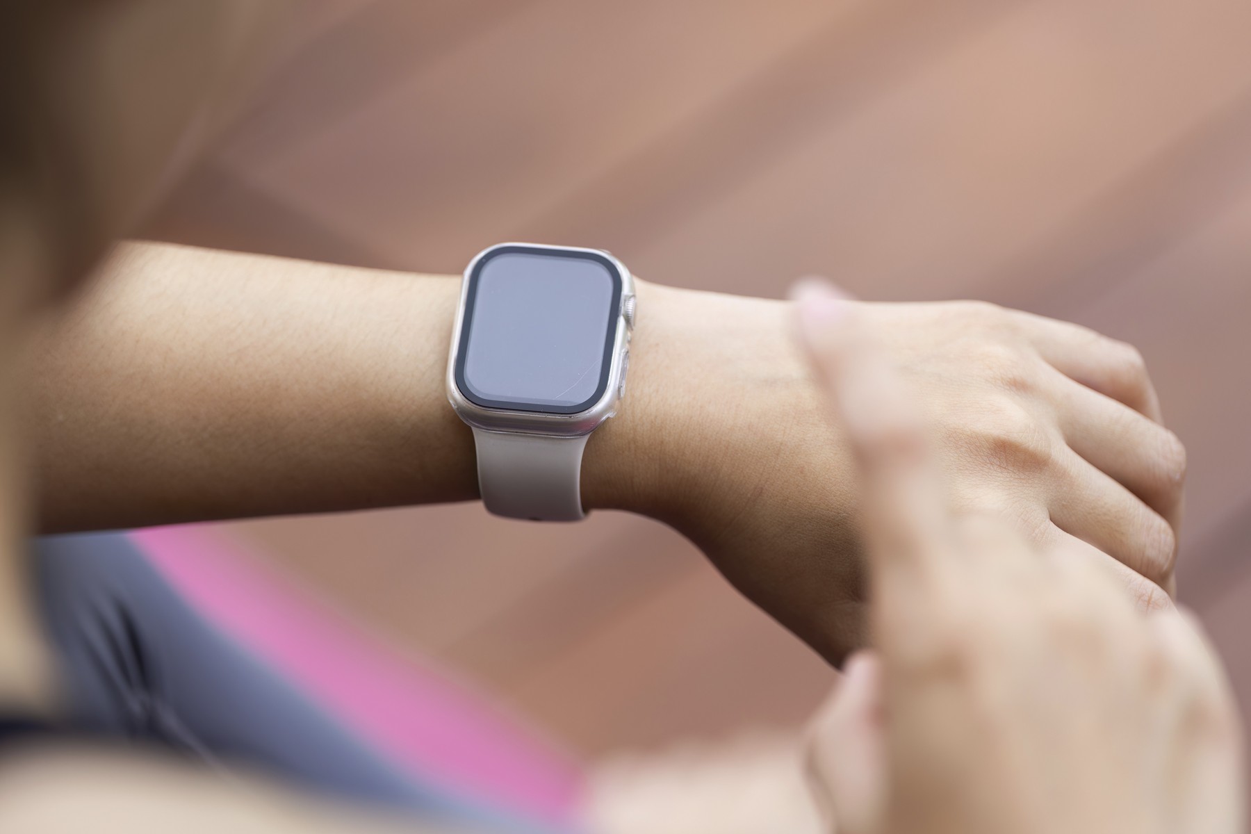 A young woman's wrist adorned with a smartwatch.