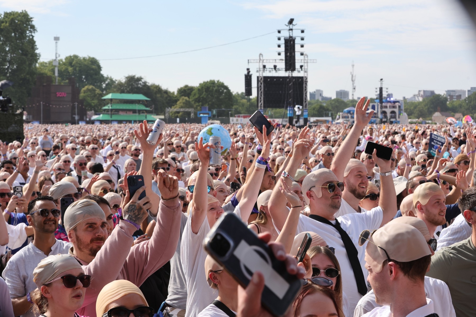 Oboževalci z maskami plešaste glave za Pitbullov poskus postavitve Guinnessovega rekorda na festivalu BST Hyde Park v Londonu