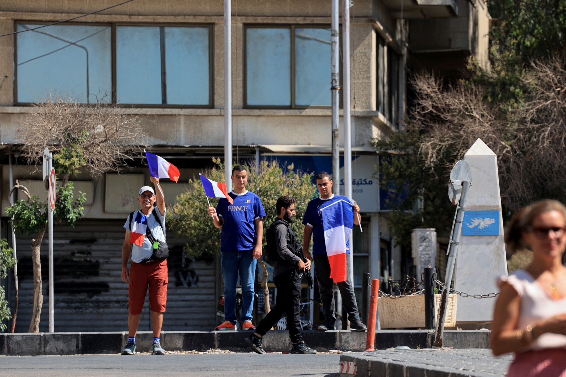 Domačini pred hotelom, v katerem prebiva Macron, s francoskimi zastavami
