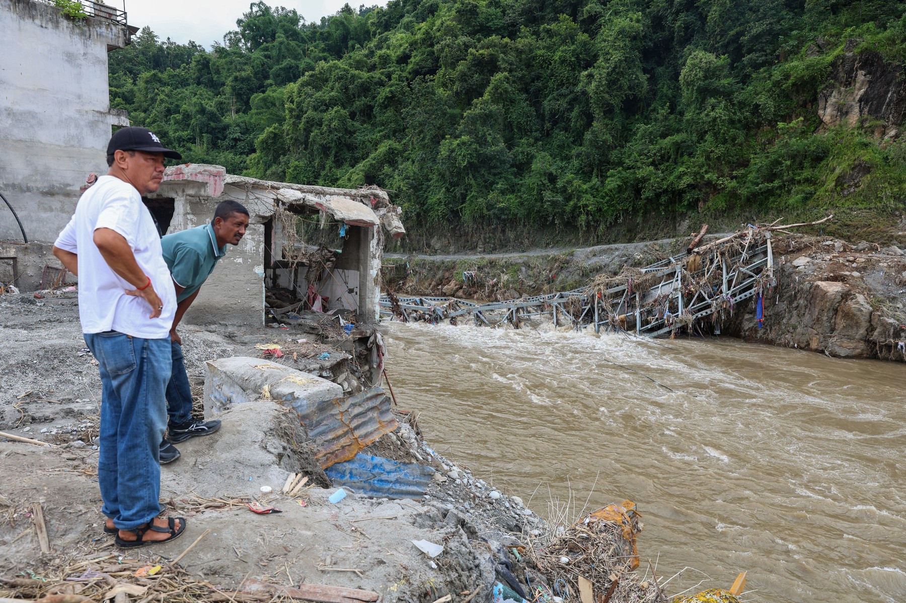 DEVIGHAT, NEPAL - AUGUST 29: Residents look at a collapsed bridge in a town