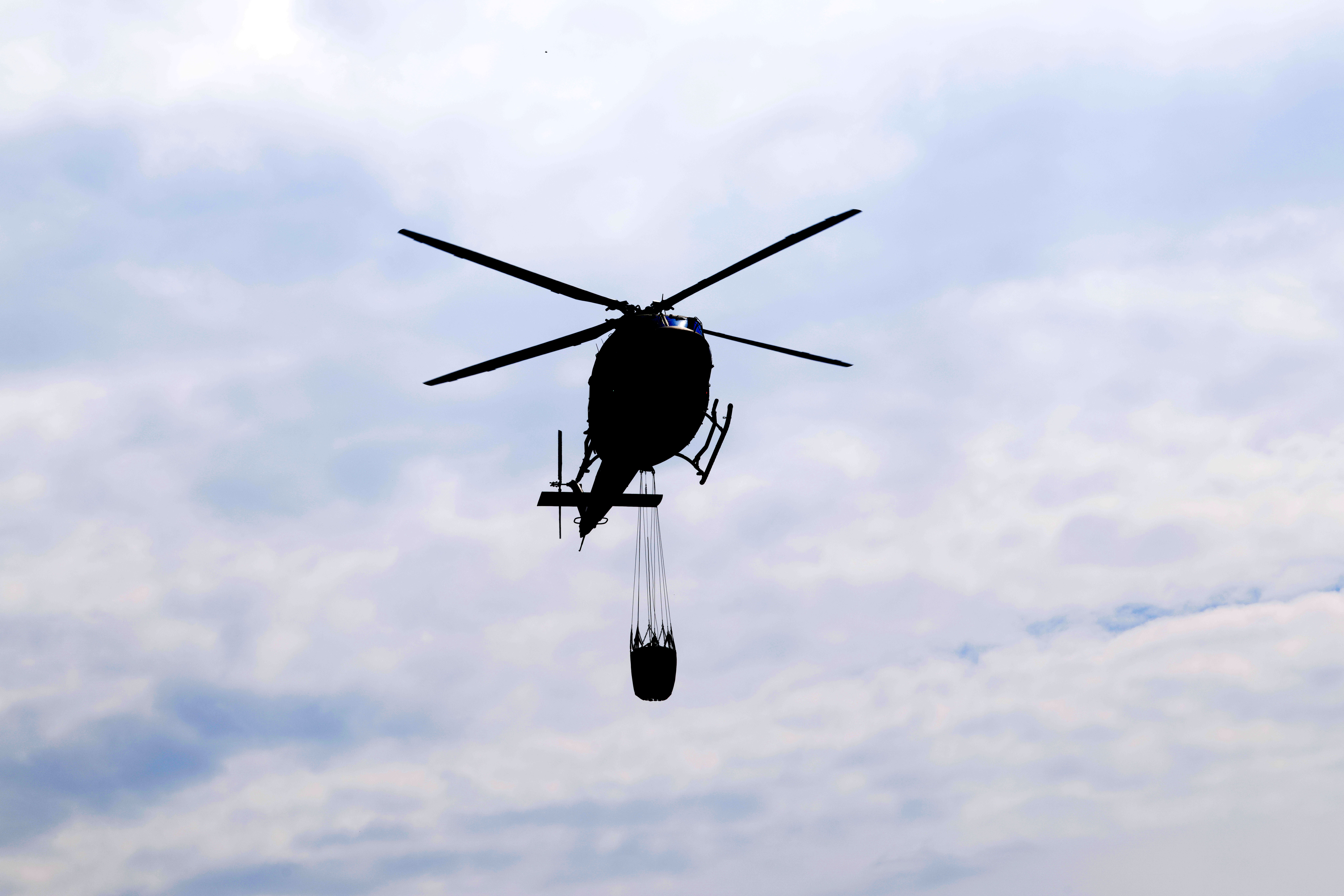 Vojaški helikopter gasi požar v Kranjski Gori