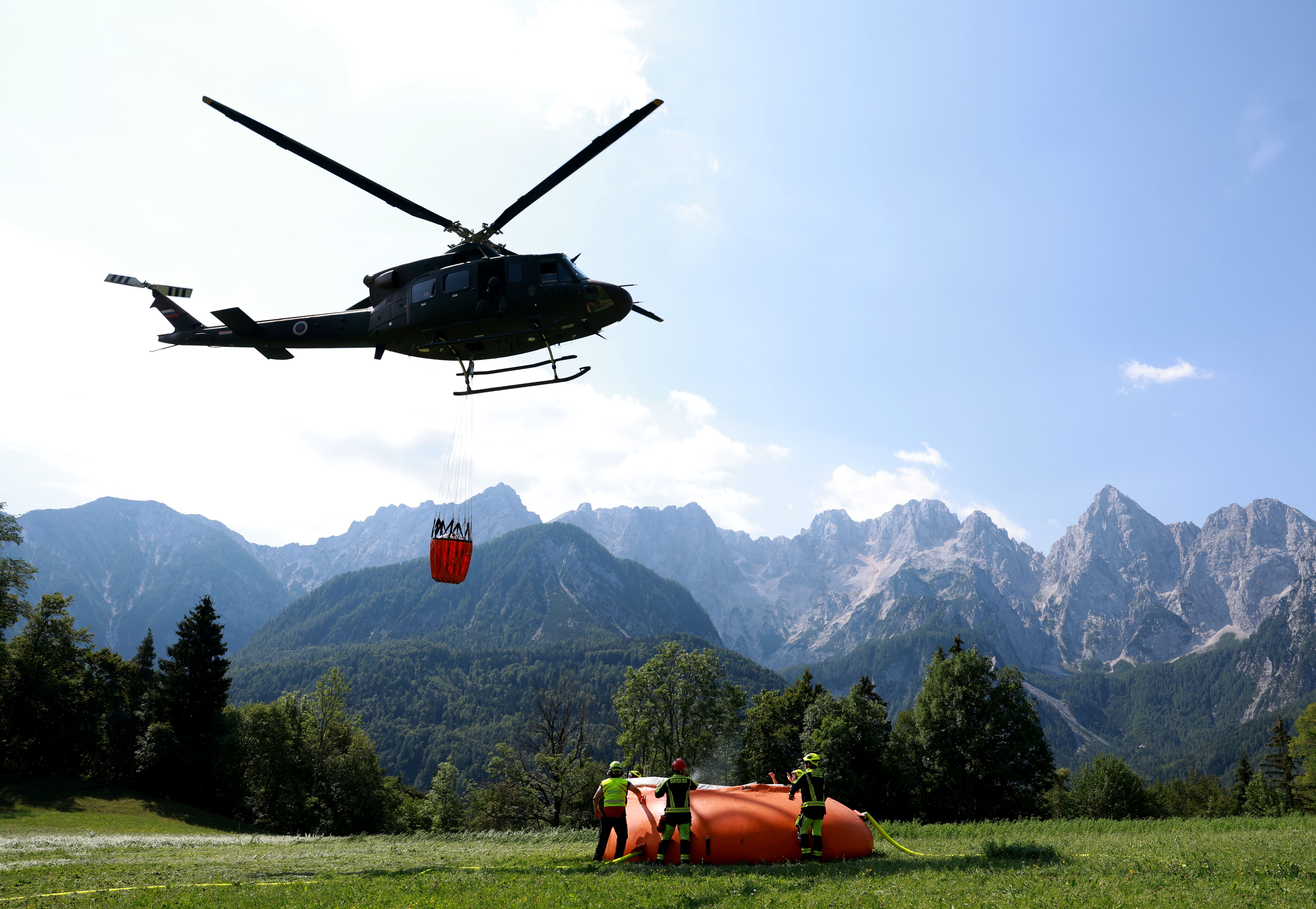 Vojaški helikopter gasi požar v Kranjski Gori