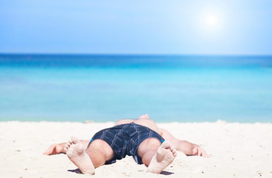 Človek leži na plaži