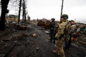 Ukrajinski vojaki si ogledujejo uničene ruske tanke