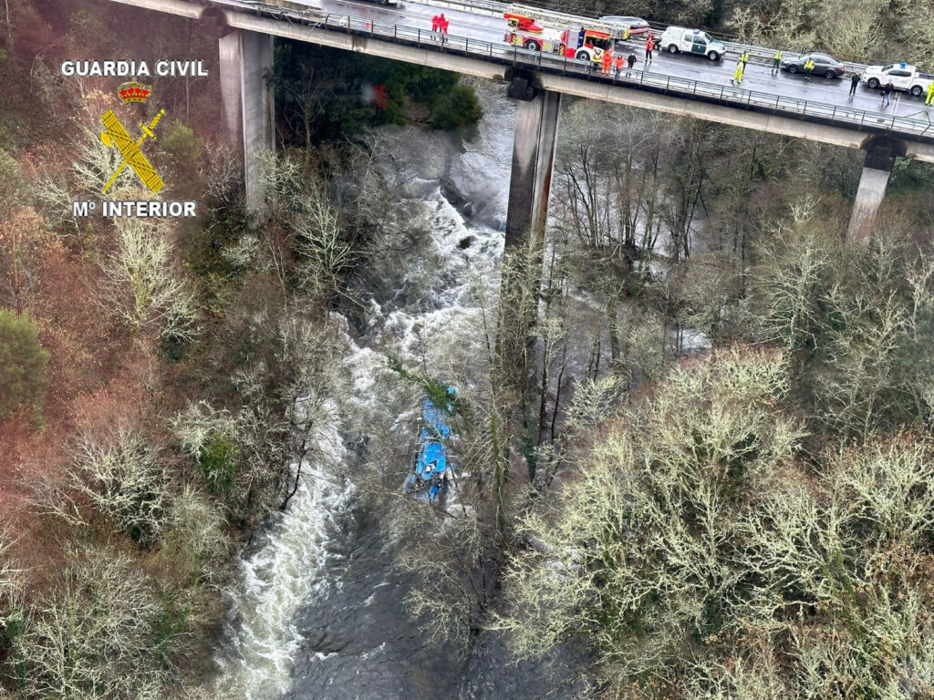 Emergency services work at the scene of an accident where a passenger bus plunged off a bridge into the river in northwestern Spain