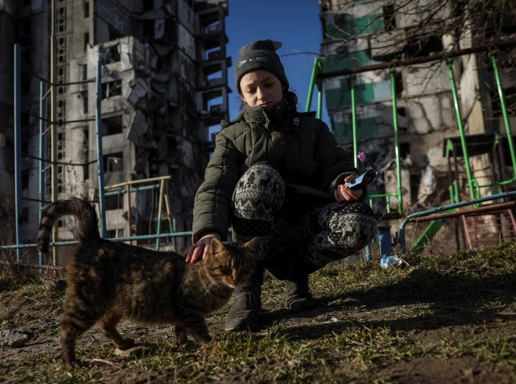 deklica in mačka pred porušeno stavbo v Borodjanki