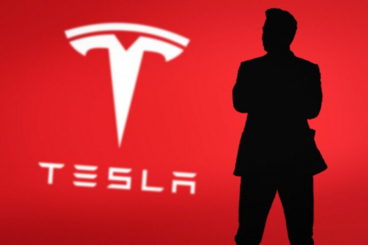 Silhueta Elona Muska ob znaku podjetja Tesla.