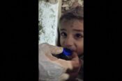 Pod potresnimi ruševinami ujeti dehidrirani deček pije vodo iz pokrovčka
