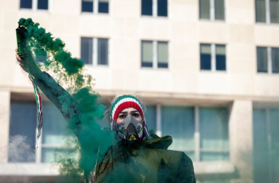 Protestnica s plinsko masko na shodu zoper islamistični režim v Iranu.