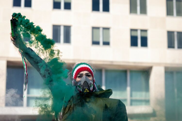 Protestnica s plinsko masko na shodu zoper islamistični režim v Iranu.