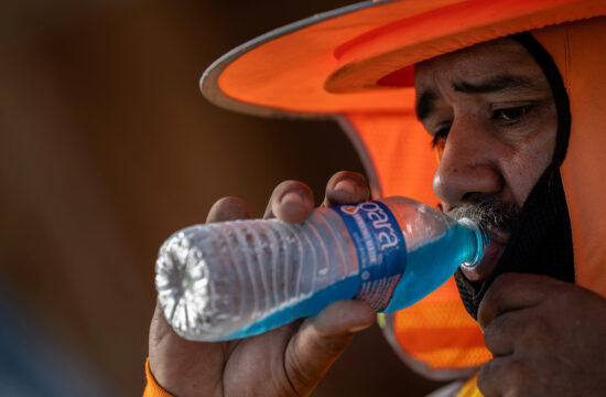 Moški pije vodo iz plastenke