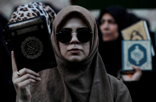Protestnica s Koranom v roki.