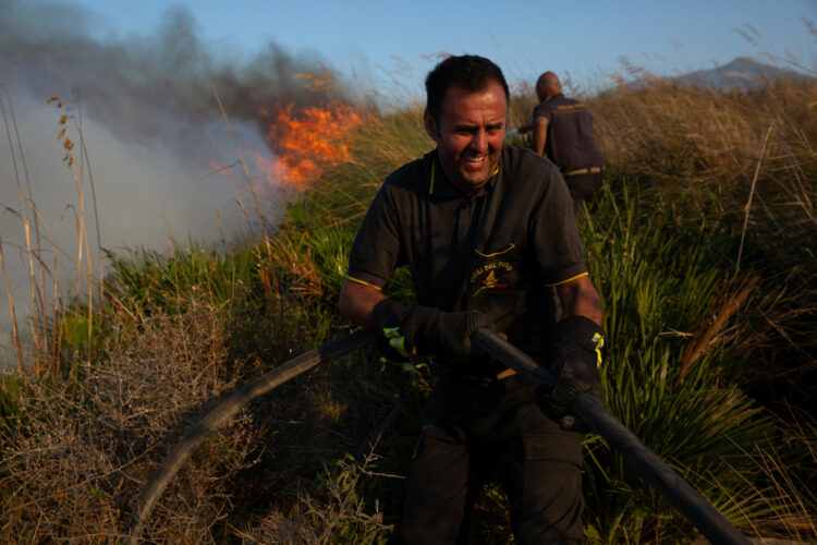 Gasilec gasi požar v Sicilija.