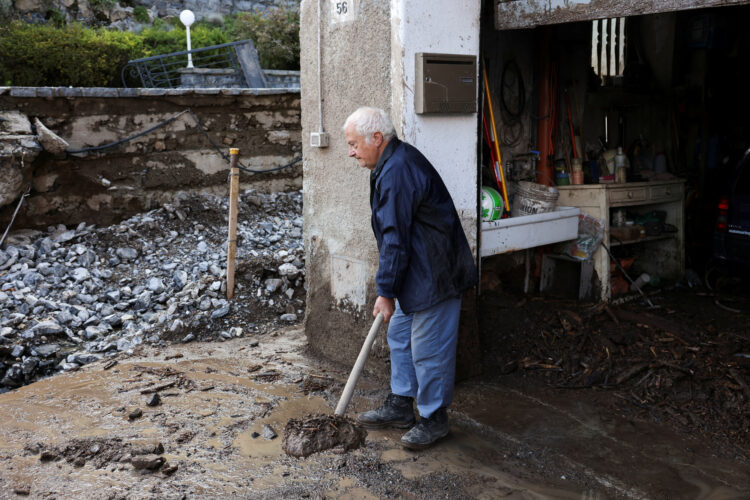 Starejši gospod čisti po poplavah.