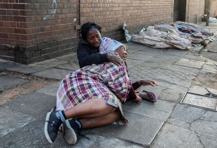 Dve ženski na ulici v Johannesburgu po požaru.