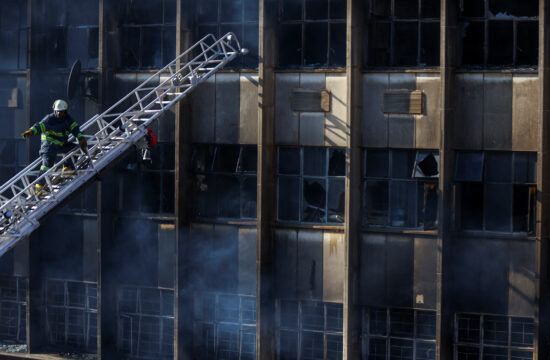 Uničena stavba v Johannesburgu in gasilec.