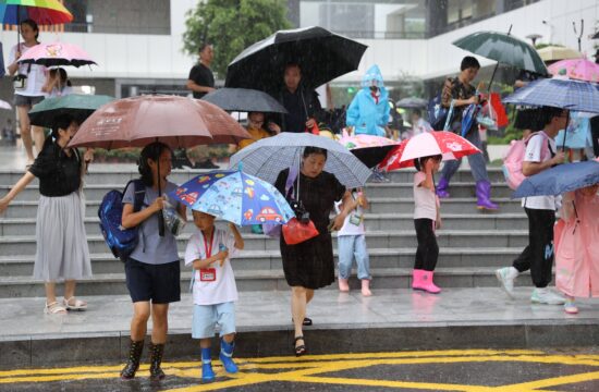 Starši so pospremili otroke iz šole v dežju.