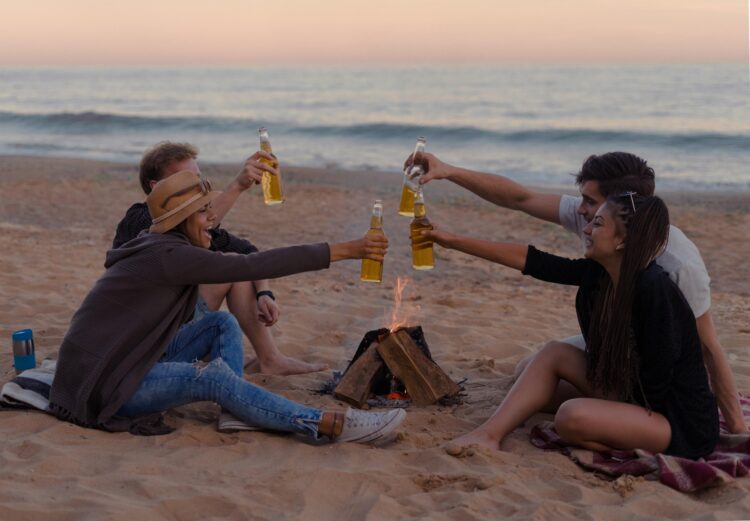 Skupina prijateljev pije na plaži