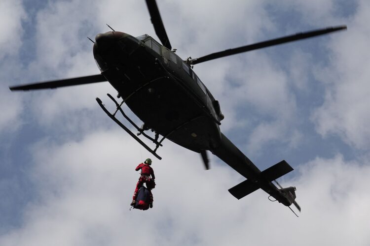 Gorski reševalec se spušča iz helikopterja.