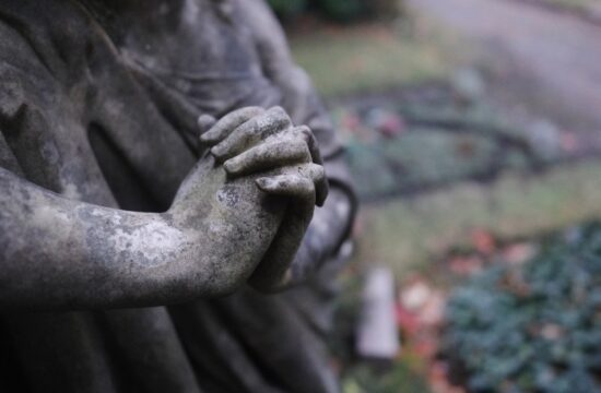 kip s sklenjenimi rokami, ki ponazarja zlorabo v cerkvi
