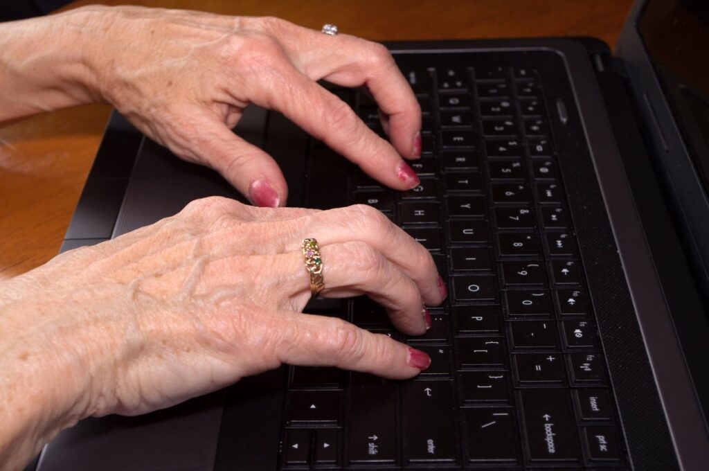 roke starejše ženske na računalniški tipkovnici