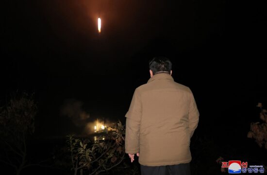 Kim Džong Un gleda proti izstreljeni raketi
