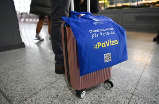 potnik na letališču z napisom za liberalizacijo viz za Kosovo