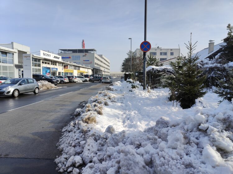 Kup spluženega snega na pločniku v Dravljah