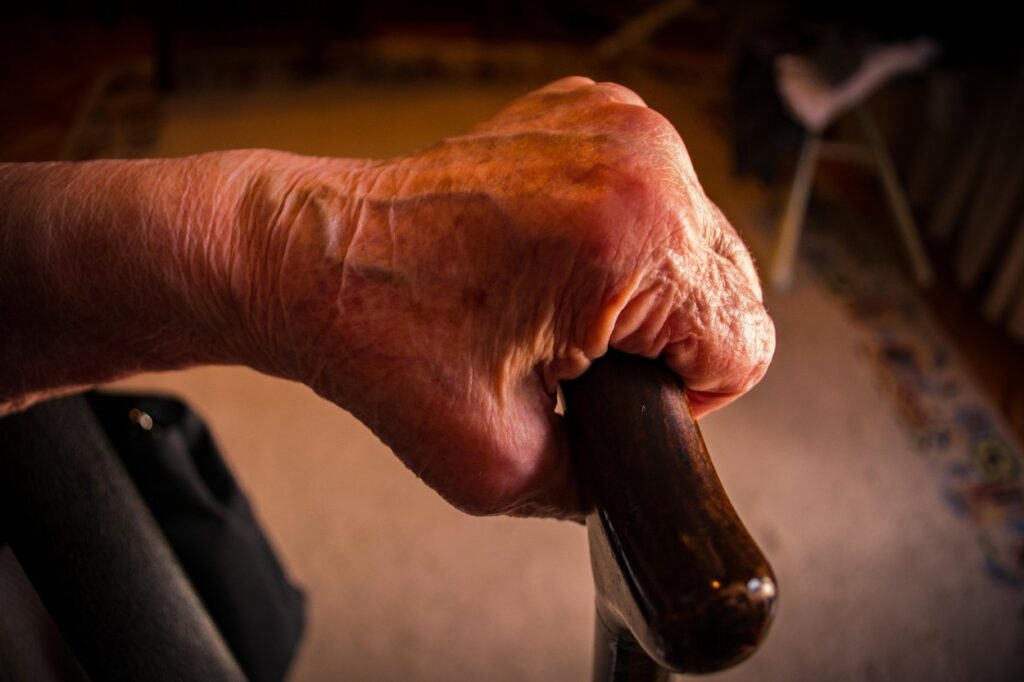 Starejša oseba drži palico