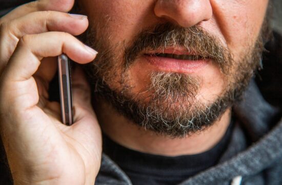 moški z brado govori po telefonu, brez oči