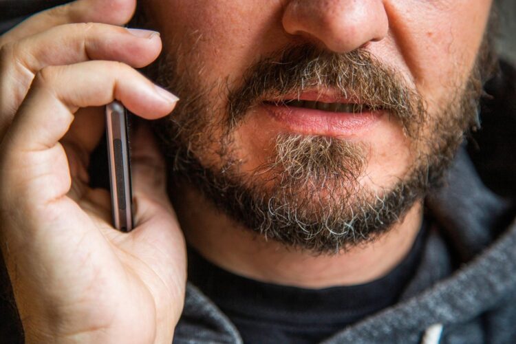 moški z brado govori po telefonu, brez oči