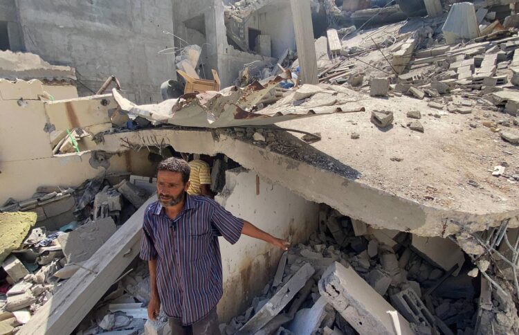 Moški preiskujejo ruševine hiše, v kateri je živela sestra vodje Hamasa