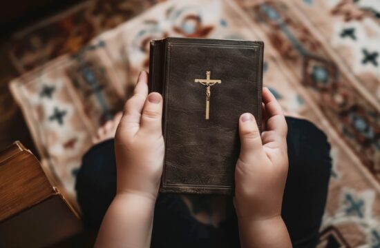 otrok v roki drži sveto pismo