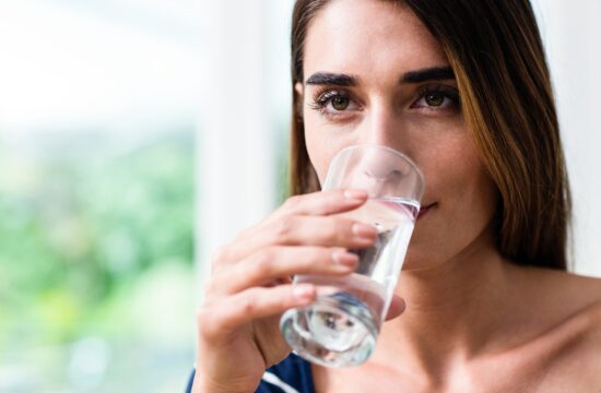 Mlada ženska pije kozarec vode