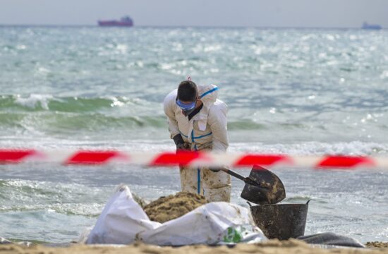 delavci čistijo plažo po onesnaženju