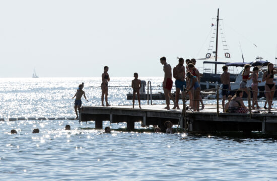 ljudje na pomolu ob slovenskem morju