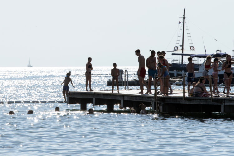 ljudje na pomolu ob slovenskem morju
