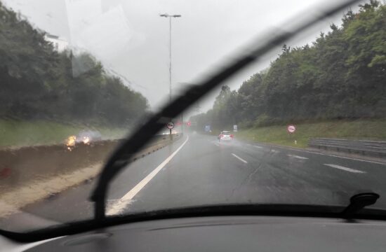 Vozila vozijo med močnim deževjem