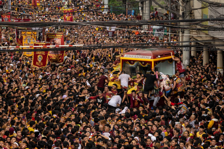 Množica Filipincev časti črnega Jezusa na procesiji